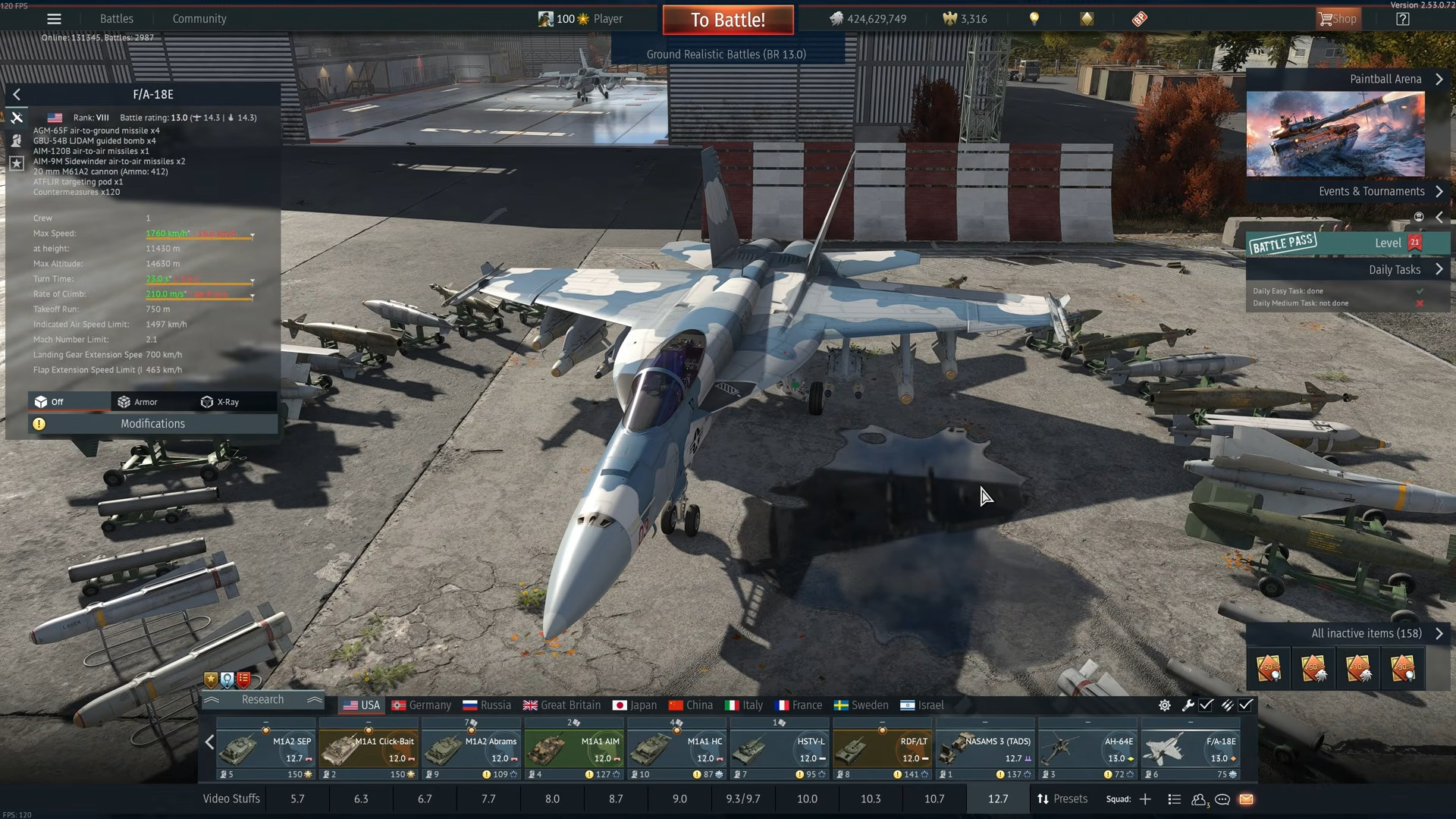 Hangar view of F/A-18E with white camouflage and full weapons loadout including AGM-65F missiles and GBU-54B bombs, stats panel open.