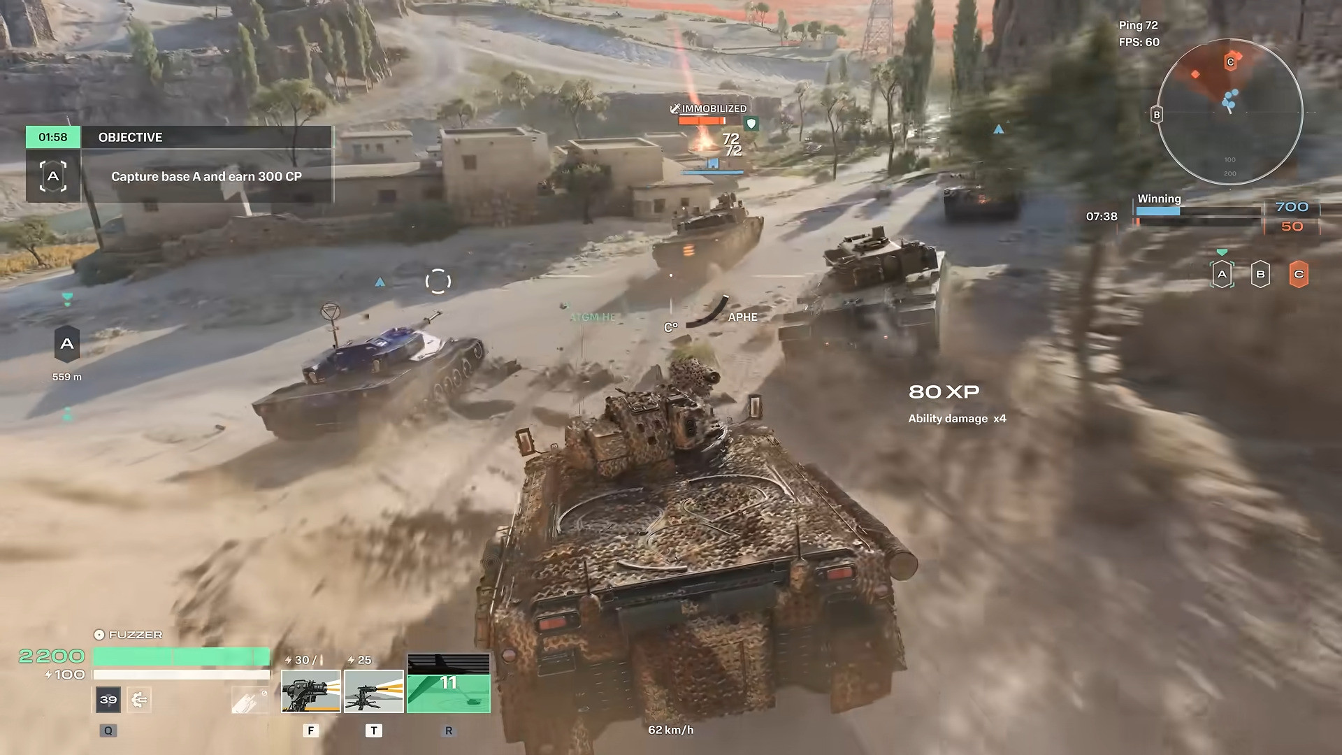 Tanks racing through a desert village toward base A with an immobilized enemy target
